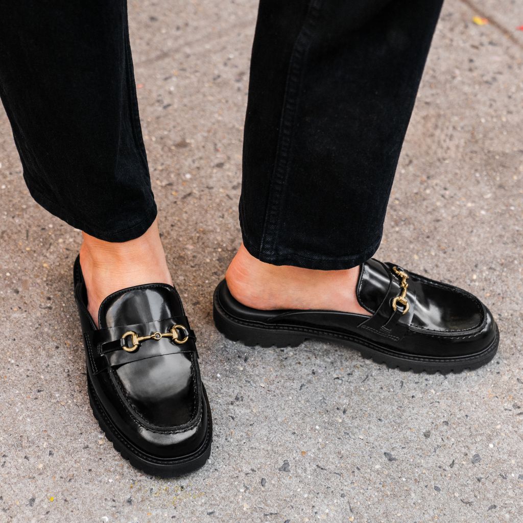 https://cdn.shopify.com/s/files/1/0419/1525/files/1024x1024-Womens-PennyMule-BlackGold-102524-1_fa19e16b-208b-4857-97a9-04d268e4afce.jpg?v=1730318490